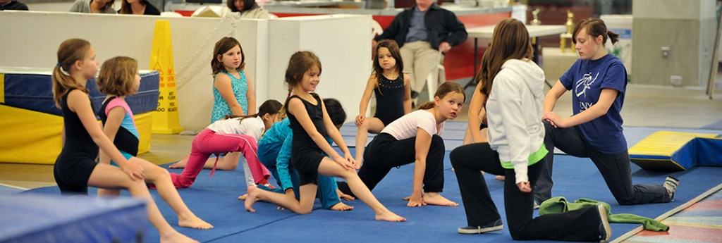 A CNY Gym Centre class stretching on the floor with coaches